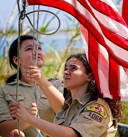 girls raising American flag